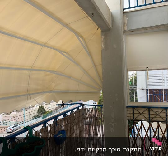 סוכך בד מתוח על מסגרת מתכת במרפסת